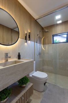 a bathroom with a toilet, sink and shower stall in the background is a window