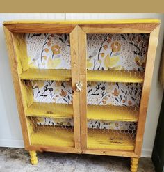 an old wooden cabinet painted yellow and decorated with flowers