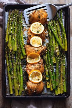 chicken, asparagus and lemons on a tray