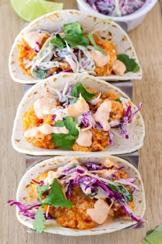 three chicken tacos with cole slaw, cilantro and lime dressing on top