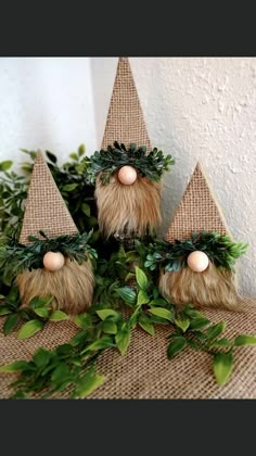 three gnomes made out of fake plants on top of a burlap table