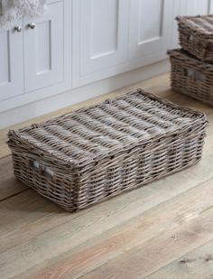 two wicker baskets sitting on top of a wooden floor