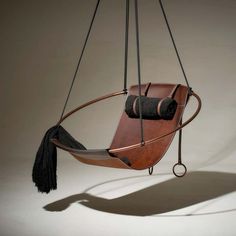 a wooden chair hanging from a metal frame