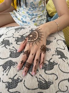 a woman's hand with henna on it sitting on top of a cushion