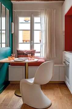 a white chair sitting in front of a window