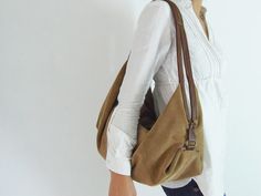 "DeLuna is a large hobo bag designed for women who love to carry slouchy handbags. Featured in this listing in suede leather, in dark brown and camel, it has plenty of room for all your essentials which makes it the perfect carryall bag. The contrast of the two-tone colors on the straps and on the main body is what makes the design unique and stand out. The straps sit comfortably on your shoulder and the bag is secured with a top zipper closure. Inside the bag, there is one main compartment with Large Hobo Bag, Suede Purse, Soft Leather Bag, Suede Bag, Bags Leather Handbags, Purse Gift, Hobo Bags, Convertible Bags, Leather Hobo Bag