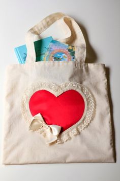 Mademoiselle Mermaid's new tote bags offer a delightfully charming way to carry around all of life's little essentials!!This cheerful red heart and muslin tote is made of 100% cotton and comes fully lined (for function!!)...while featuring a playfully over-sized heart applique pocket (for fun!!)Perfect for shopping excursions, beach days, trips to the library...or anytime you want to add a dash of whimsy to your day!!...Makes a great gift too!!♥14"x14" size.♥100% cotton; natural muslin.♥Fully li Cute Red Bags For Gifts, Cute Red Bag For Gift, Cute Canvas Shoulder Bag For Gifts, Cute Canvas Shoulder Bag For Gift, Cute Heart-shaped Bags For Gifts, Cute Beige Shoulder Bag As Gift, Valentine's Day Heart-shaped Bag With Removable Pouch, Cute Heart-shaped Gift Bags, Cute Red Bags For Valentine's Day