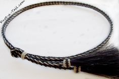 a close up of a black and white braided necklace with an animal's tail