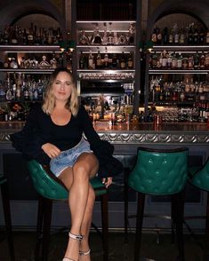 a woman sitting at a bar with her legs crossed