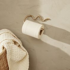 a white towel hanging on the wall next to a roll of toilet paper