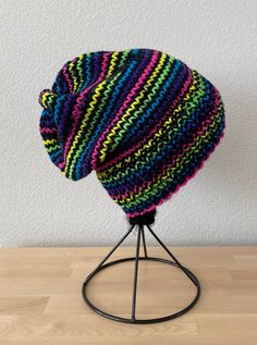 "A lovely handmade knit hat. A very versatile design. I knit the ribbing longer so you can wear it slouchy, or cuff the rim for a more fitted style.  Knit in a lovely acrylic blend yarn. Lovely neon rainbow stripes. I knit the ribbing on smaller needles, so it keeps its shape and fits well, beyond the first wear. Prevents the hat from getting too stretched out and not fitting properly.  Dimensions are (when laying flat) 7.25\" across the brim and 9.5\" tall. The hat is stretchy so will fit a var Knitted Acrylic Beanie One Size, One Size Knitted Acrylic Beanie, One Size Acrylic Knitted Beanie, Cozy Beanie Knitting Pattern One Size, Multicolor Yarn Beanie Cap, Adjustable Soft Knit Crochet Hat, Multicolor Yarn Beanie, Handmade Beanie Knitting Pattern, Hand Knitted Beanie Knitting Pattern With Acrylic Yarn