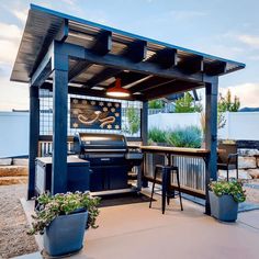 an outdoor kitchen with grill and seating area