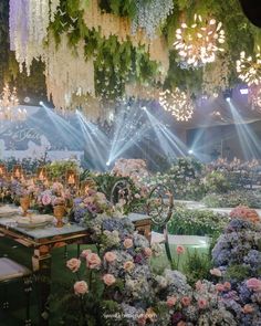 an outdoor event with flowers and chandeliers