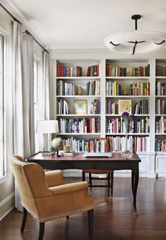 a living room filled with furniture and lots of bookshelves full of books on top of them