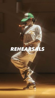 a baseball player in white uniform and green hat with the words rehearsals on it