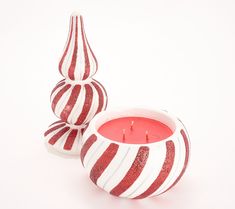 two red and white striped candles sitting next to each other