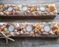 two candles are sitting on top of some seashells