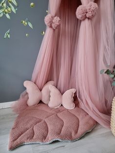 a pink canopy bed with two butterflies on it