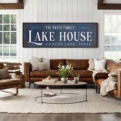 a living room filled with furniture and a large lake house sign above the couches