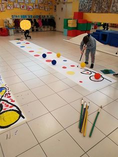 two children are playing with colored crayons on the floor in front of them