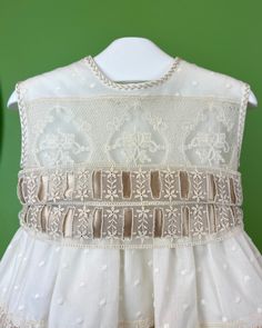 An elegant and unique gown for babies, unisex. It is made with beautiful laces and ribbons making this gown special. It comes with a bonnet and has buttons on the back for closure. Dry Clean Made in Spain Final Sale, no exchanges nor returns will be accepted Cream Lace Ruffle Dress For Baptism, Cream Ruffled Lace Dress For Baptism, Formal Lace Dress With Lace Patchwork, Elegant Beige Dress For Dress-up Occasions, First Communion Lace Dress With Lace Collar, Ceremony Baptism Dress With Lace Trim And Fitted Bodice, Sleeveless Lace Dress With Lace Bodice For Baptism, Elegant First Communion Dress With Lace Collar, Sleeveless Lace Bodice Dress For Baptism