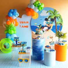 a mickey mouse themed birthday party with balloons and decorations