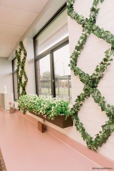 an office building with plants growing on the wall and window sill in front of it