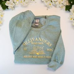 This cozy and durable 10 Oz heavyweight hoodies are perfect for any wizarding fan. Made from a blend of cotton and recycled polyester, they make great gifts or a wonderful treat for yourself. Our hoodies features a unique embroidered design inspired by the wizarding world #OllivandersSweater #Ollivanders #HarryPotter #HarryPotterSweater Crewneck Embroidery, Harry Potter Sweatshirt, Wizard School, Harry Potter Shirts, Embroidery Sweater, Embroidery Sweatshirt, Embroidered Crewneck, Etsy Personalized Gifts, Embroidered Clothes