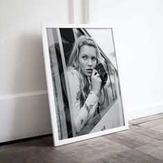 a black and white photo of a woman holding a camera