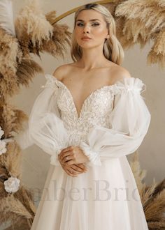 a woman in a wedding dress standing next to some feathers