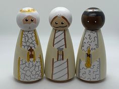 three wooden figurines are standing next to each other