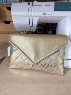 a gold purse sitting next to a sewing machine