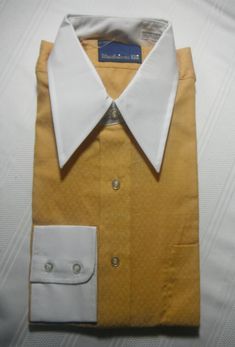 Vintage golden yellow shirt, white collar & cuffs, 65% Dacron Polyester & 35% Combed Cotton, never worn, in original package, never opened. Collar 15.5in. sleeves 33in. Yellow Formal Shirt For Spring, Formal Yellow Shirt For Spring, Gold Long Sleeve Cotton Shirt, Spring Formal Yellow Shirt, Spring Yellow Formal Shirt, Formal Yellow Cotton Shirt, Classic Gold Shirt For Formal Occasions, Fitted Gold Shirt With Button Closure, Elegant Yellow Long Sleeve Shirt