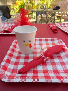 a red and white checkered table cloth with a cup on it