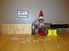 an elf is sitting on top of a hammer and some screwdrivers in front of him