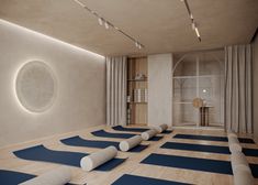 there are many yoga mats on the floor in front of a wall with a circular window