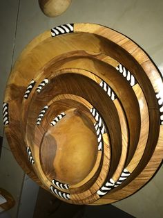 several wooden bowls stacked on top of each other with black and white designs in them