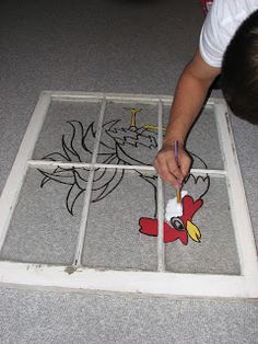 a child is drawing on the floor with markers