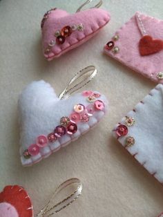 three pieces of felt with buttons and sequins are arranged on a white surface