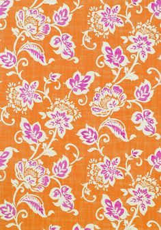 an orange and pink floral fabric with white flowers on the top, in different colors