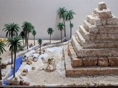 a desert scene with palm trees, rocks and sand in the shape of a pyramid