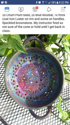 a blue bowl sitting on top of a table next to a planter with green leaves