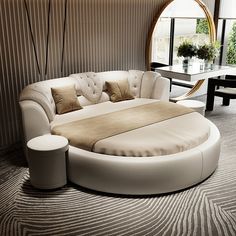 a large round bed sitting in the middle of a living room next to a table