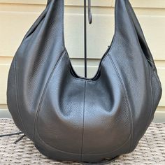 Slouchy Hobo Bag With A Unlined Interior And Attached Zip Pouch. Measures 19.5”Wx14”Hx1”D. Strap Drop 10”. Elegant Black Hobo Shoulder Bag, Luxury Hobo Shoulder Bag For Everyday, Luxury Hobo Bag For Everyday, Black Leather-lined Hobo Bag In Tote Shape, Black Leather Lined Hobo Tote Bag, Modern Hobo Bag With Leather Lining For Errands, Black Leather Lining Hobo Tote Bag, Black Leather-lined Tote Hobo Bag, Luxury Black Hobo Bag For Errands