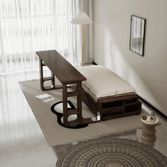 a living room with a couch, table and rug on the floor in front of a window