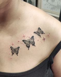 three butterflies on the back of a woman's chest, with stars in the background