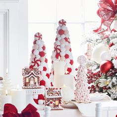 a table topped with lots of white and red christmas decorations