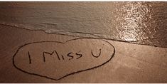 i miss u written in the sand with a heart