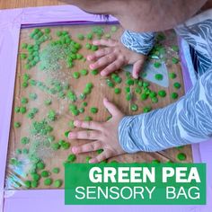 two children are playing with green pea seeds on a wooden table and the text overlay reads, green pea sensory bag