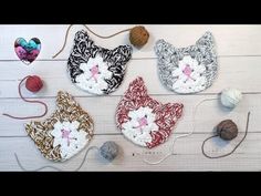 four crocheted cats sitting on top of a table next to balls of yarn